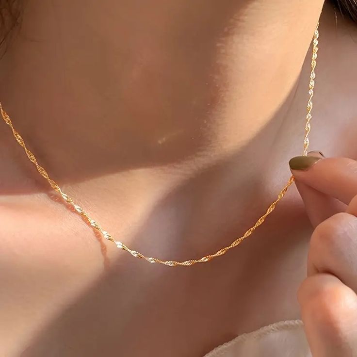 A close-up image of a 16-inch 22k gold plated sterling silver chain around a person's neck, showcasing its sleek and elegant design.
