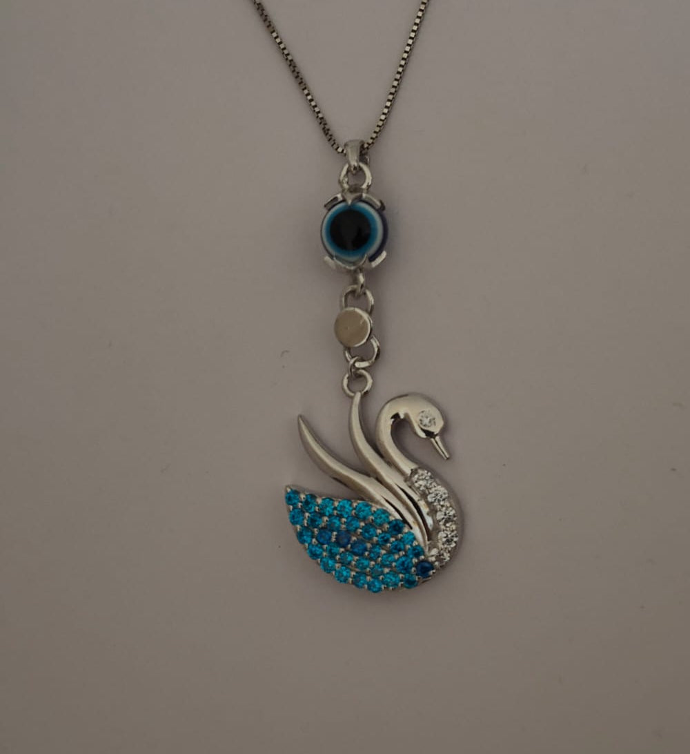 A silver-tone chain necklace featuring a swan pendant embellished with bright blue rhinestones on its body and a small oval blue stone above it, displayed against a plain light gray background.