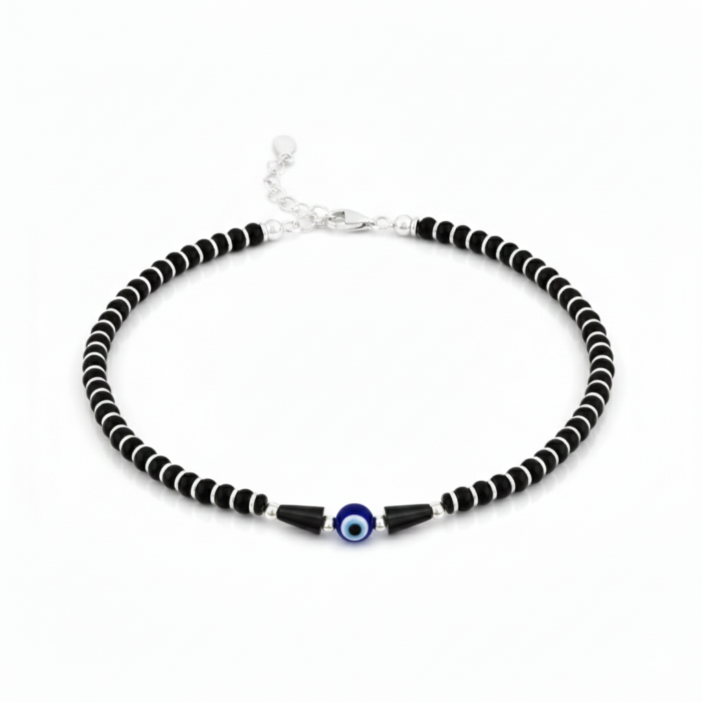 Black and white beaded necklace with a blue evil eye charm on a white background