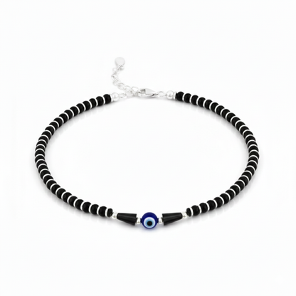 Black and white beaded necklace with a blue evil eye charm on a white background