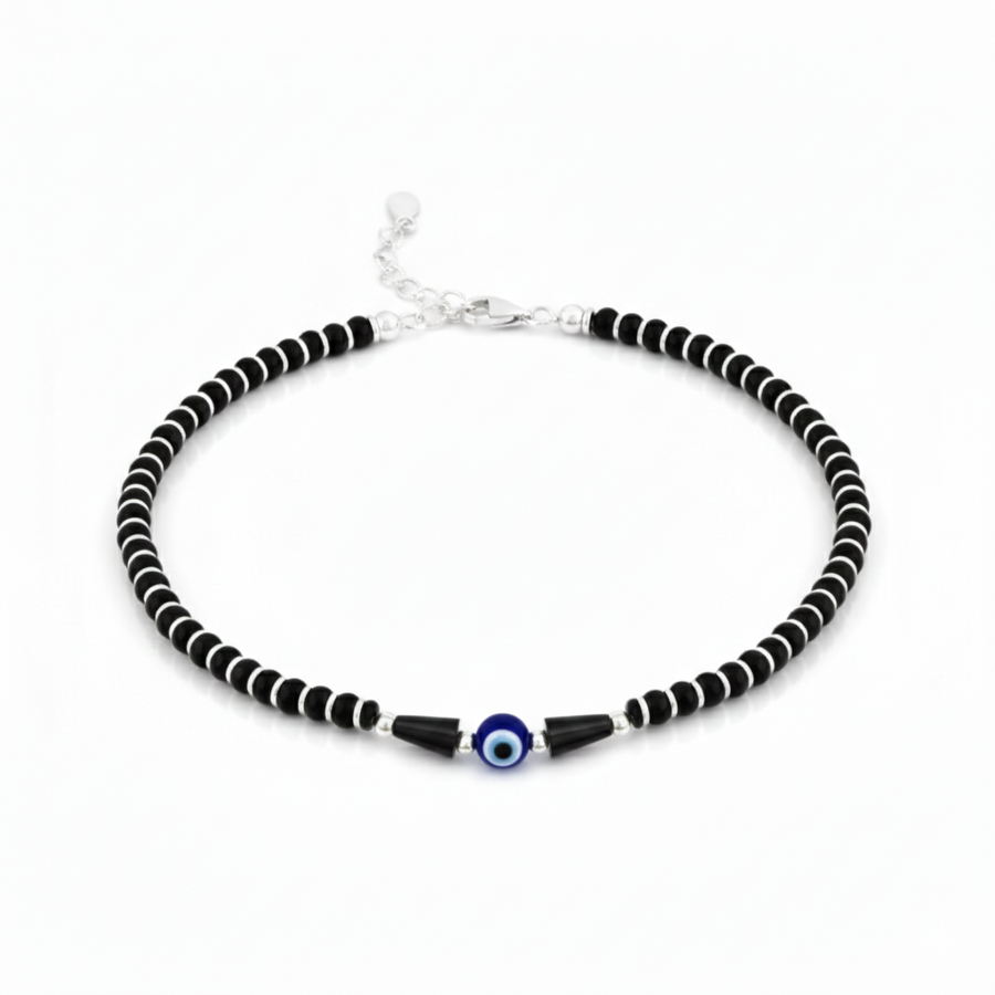 Black and white beaded necklace with a blue evil eye charm on a white background