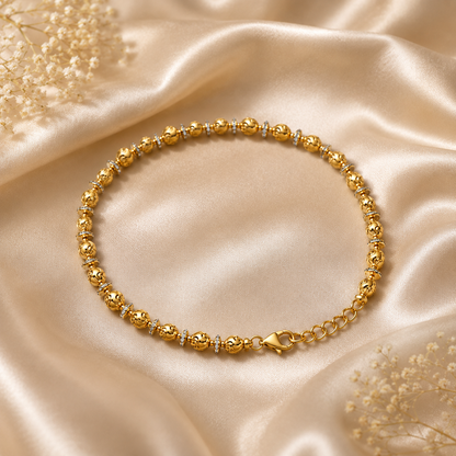 Gold anklet with small diamonds on a beige satin background
