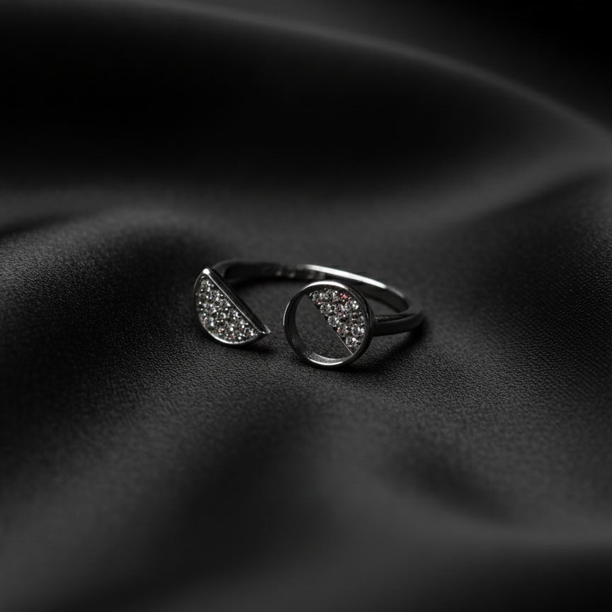 Rivansh asymmetric ring in 925 fine silver featuring a graduated multi-size stone row layout on black silk cloth background