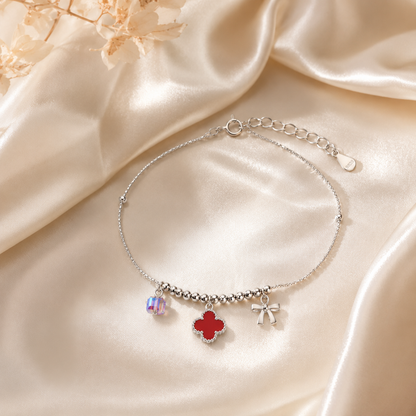 Silver anklet with charms on a beige satin background