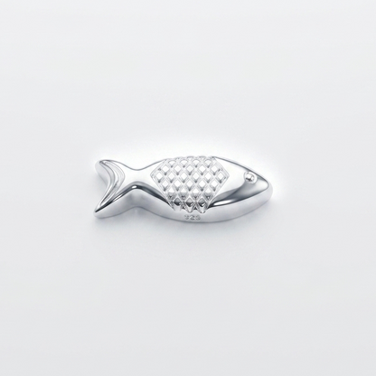 Silver fish-shaped object on a light gray background