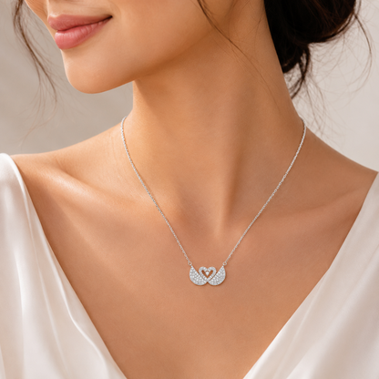 Silver necklace with a heart pendant worn by a model against a neutral background