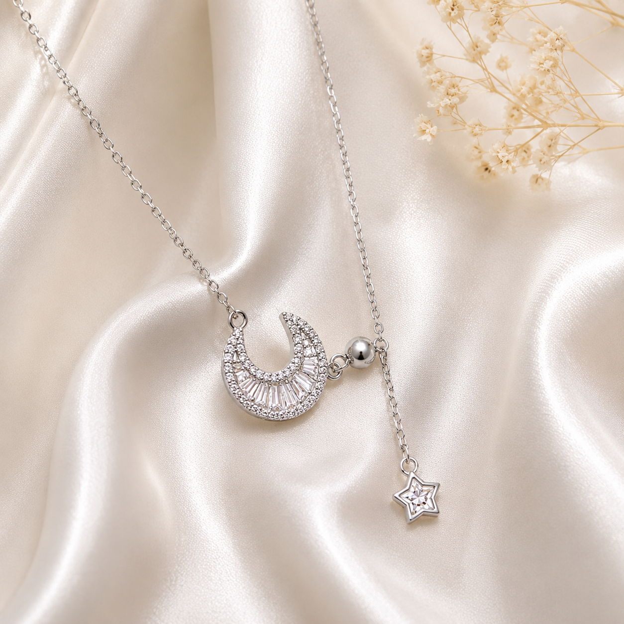 Silver necklace with crescent moon and star pendant on a satin surface