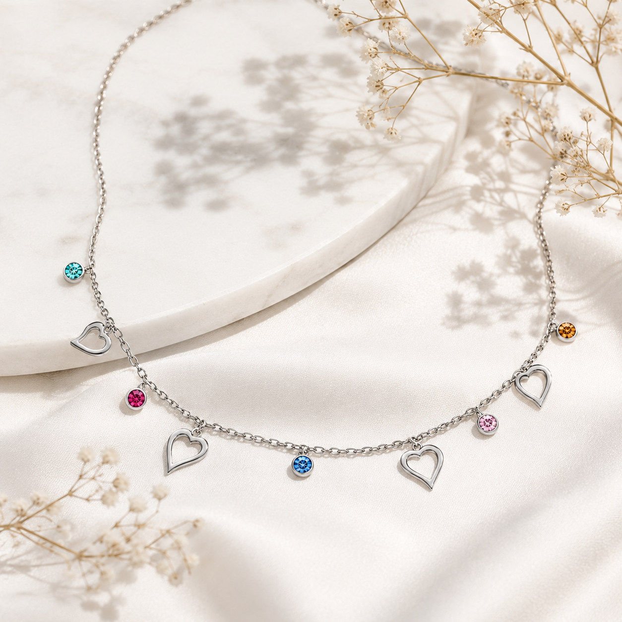 Silver necklace with heart-shaped charms on a light background