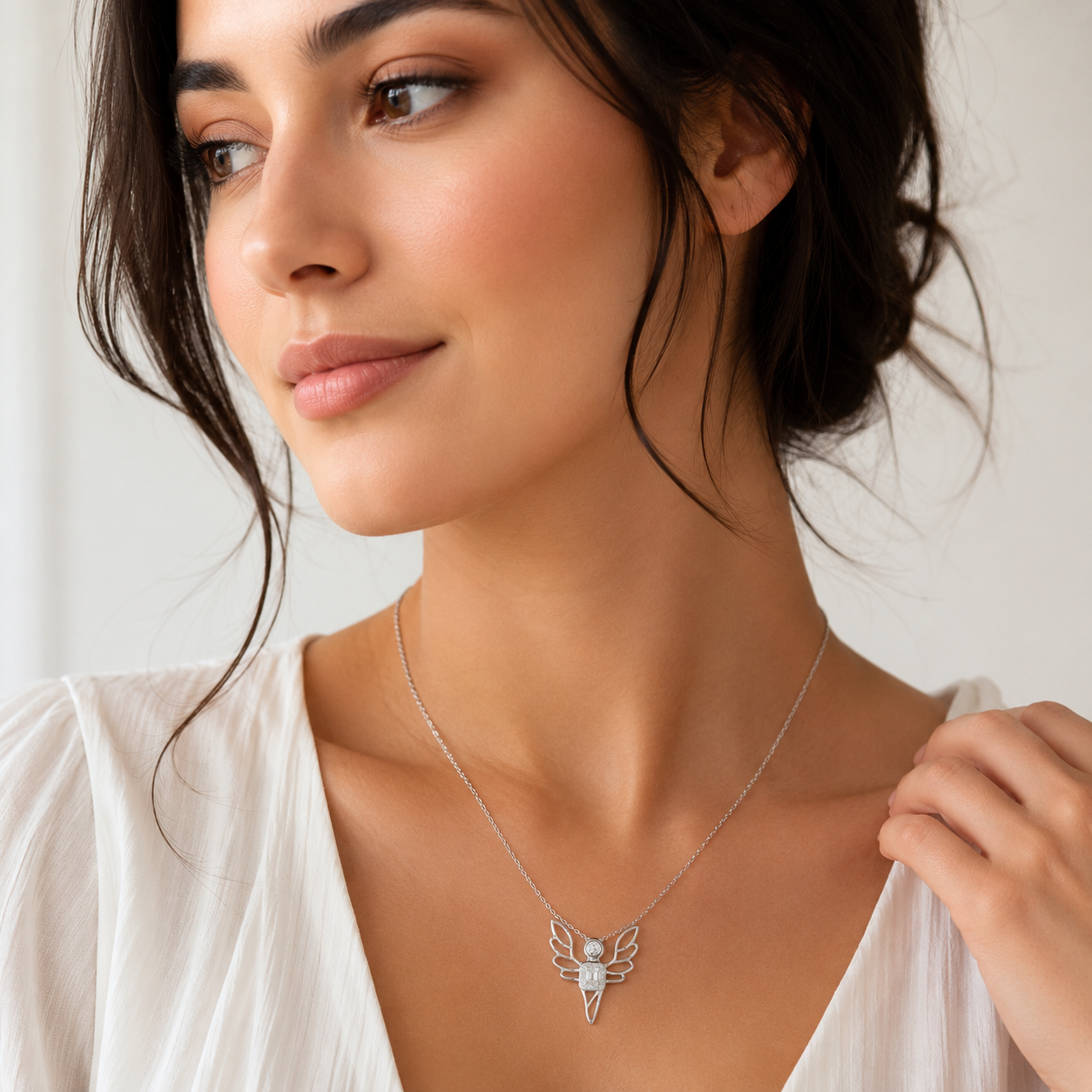 Woman wearing a delicate silver necklace with a butterfly pendant against a neutral background